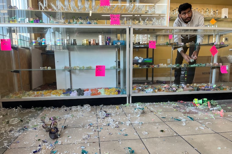 Hasan Raza cleans up in the aftermath of a 7.0 earthquake inside E&J Liquors in Rio Dell, Calif., on Thursday, Dec. 5, 2024.