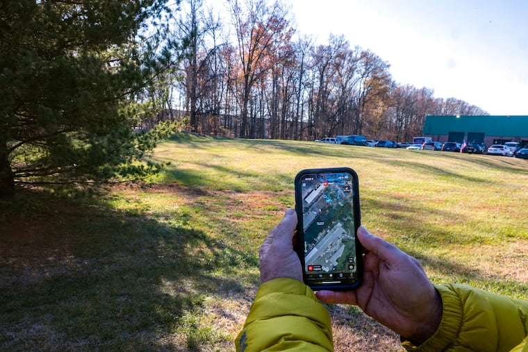 Mark Pensiero holds a map of thin parcel of land off Lenola Road in Moorestown. Environmentalists say the township would set a bad precedent by approving a variance for a development plan, which includes cutting down 227 trees.