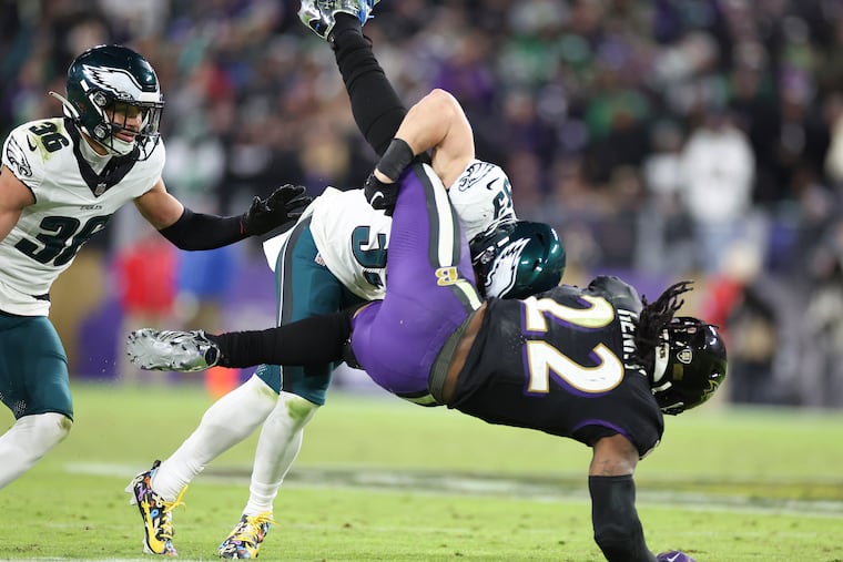 Eagles cornerback Cooper DeJean tackles Ravens running back Derrick Henry in the fourth quarter as Tristin McCollum moves in.