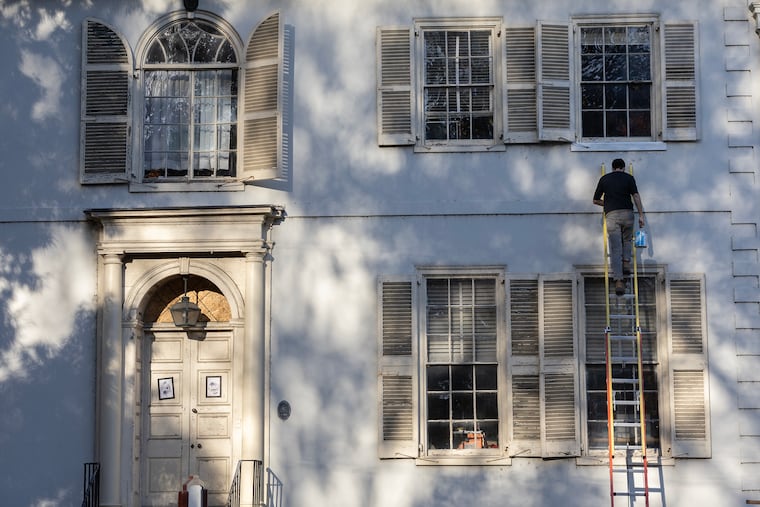 Work continues on the windows at Fairmount Park's Sweetbriar Mansion. Andrew Staples of the Fairmount Park Conservancy climbs a ladder to prime a new windowsill.