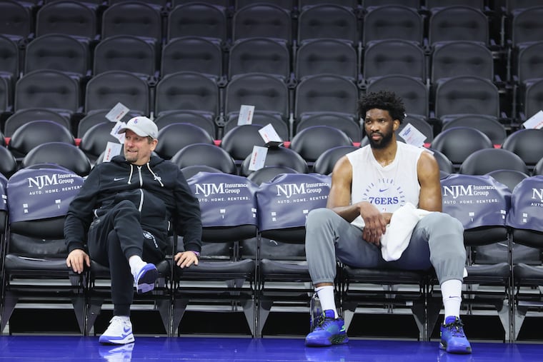 Joel Embiid (right) sits with Sixers coach Nick Nurse before Wednesday's game. Embiid will miss Friday's matchup with the Magic.