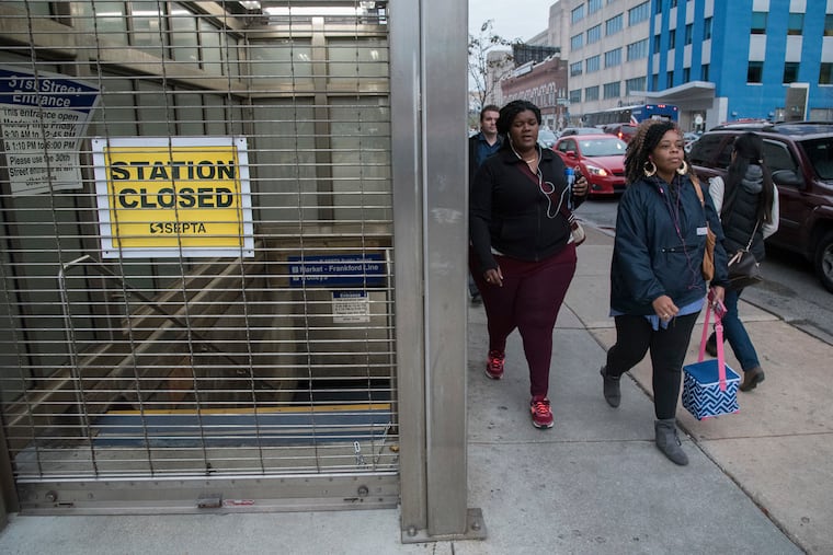 Commuters pass the closed SEPTA station at 31st Street and Market during the afternoon commute on the first day of a SEPTA strike on Nov. 1, 2016.